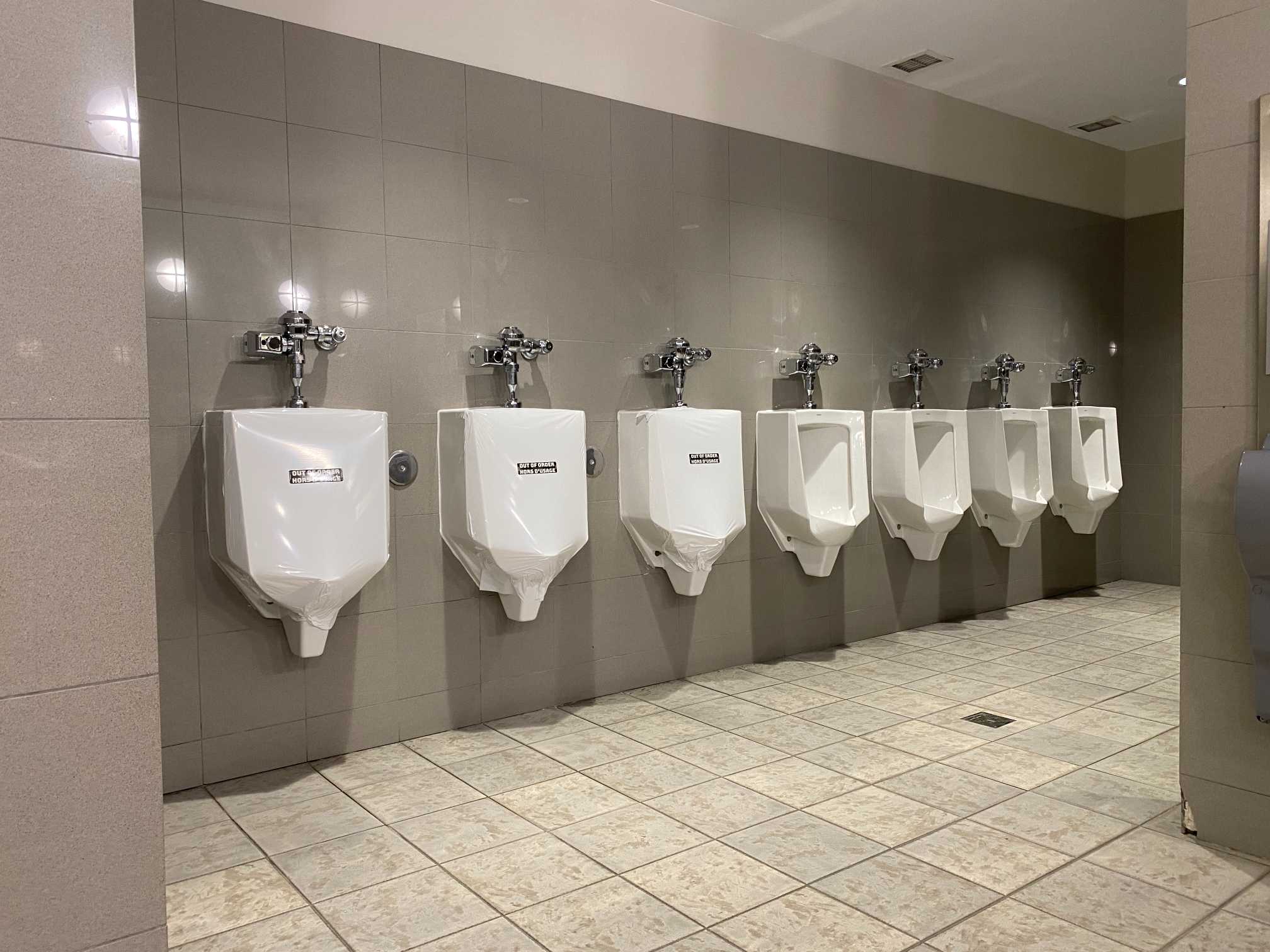 Out-of-service urinal covered with a fixture wrap